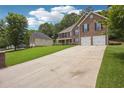 Spacious driveway leading to a two-story brick home with an attached two-car garage at 4549 Clarks Creek Ter, Ellenwood, GA 30294