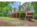 Lovely home featuring a classic brick facade, dormer windows, and a covered front porch at 15 Walnut Ridge Way, Covington, GA 30014