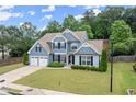 Two-story home with an attached two-car garage sits on a lush green lawn at 214 Crestmont Way, Canton, GA 30114