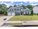 Inviting two-story home features a well-maintained lawn and attached two-car garage at 214 Crestmont Way, Canton, GA 30114