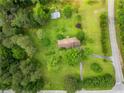 An aerial view of the property showcasing the house, green lawn, trees, and surrounding landscape at 4380 Highway 138, Oxford, GA 30054
