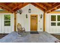 Inviting front porch with wood columns, charming rocking chair, stone flooring, and wood door at 1016 Green Dr, Canton, GA 30114