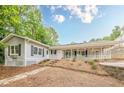 View of the back exterior featuring a long porch, white railings, and well-maintained landscaping at 2555 Chattahoochee Ln, Cumming, GA 30041