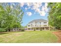 Expansive backyard showcasing a large deck, lush lawn, and charming outbuilding at 2555 Chattahoochee Ln, Cumming, GA 30041