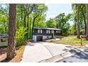 Beautiful gray house showcasing a driveway and lush green trees at 809 Vinton Wood Rd, Forest Park, GA 30297