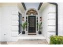 Elegant entryway with black door, white brick, and arched window detail with modern sconces at 823 Laurel Crest Sw Ct, Marietta, GA 30064