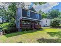 View of the home's exterior showing the front lawn and inviting porch, surrounded by trees at 233 Clayton St, Fairburn, GA 30213