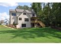 Spacious backyard with large lawn, mature trees, and a covered deck at 333 Mont Harmony Sw Rd, Powder Springs, GA 30127