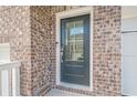 Close-up of a stylish front door with glass pane and brick surround at 123 Matson Sw Run, Mableton, GA 30126