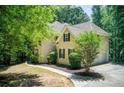 Side view of a well-manicured two-story home with an attached garage and a winding walkway at 245 Ashley Forest Dr, Fayetteville, GA 30214