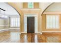 Elegant foyer with gleaming hardwood floors, high ceilings, and large windows with white shutters at 245 Ashley Forest Dr, Fayetteville, GA 30214