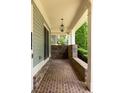 Covered front porch with brick flooring, decorative brick columns, and a view of the landscaped front yard at 775 A Harrison Se Pl, Atlanta, GA 30315
