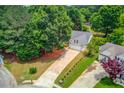 Aerial view of a home with a long driveway surrounded by mature trees and landscaping at 627 New England Way, Lawrenceville, GA 30046