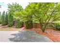 This backyard features mature trees, a wooden fence, and some shade at 627 New England Way, Lawrenceville, GA 30046