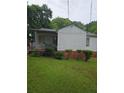 View of the home's exterior, featuring a covered patio and grassy lawn area at 4253 Hanes Dr, Decatur, GA 30035