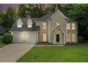 Charming two-story home with a two-car garage, well-manicured lawn, and mature trees at 6895 Old Fox Trl, Stone Mountain, GA 30087