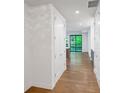 Hallway with hardwood floors, white walls, and a view of the outdoors through a black-framed window at the end of the hall at 867 Peachtree Ne St # 202, Atlanta, GA 30308