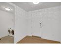 Clean laundry area featuring modern washer and dryer units and a door, all accented by light hardwood flooring at 867 Peachtree Ne St # 202, Atlanta, GA 30308