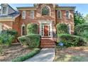 Charming brick home featuring a well-manicured front yard, a brick walkway, and an inviting red front door at 1885 Milfield Cir, Snellville, GA 30078