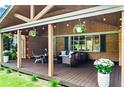 Spacious covered porch featuring stained wood ceiling, hanging string lights, seating, and potted plants at 3843 Lake Se Dr, Smyrna, GA 30082
