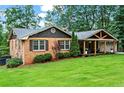 Charming brick home featuring a spacious covered porch with a gable and a large yard at 3843 Lake Se Dr, Smyrna, GA 30082