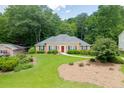 Beautiful house exterior with lush green lawn and landscaping, surrounded by mature trees at 402 Johannah Sw Pl, Lilburn, GA 30047