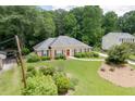 Inviting home exterior with green lawn, lush landscaping, and mature trees at 402 Johannah Sw Pl, Lilburn, GA 30047
