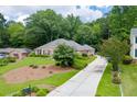 Spacious home exterior with a long driveway, lush lawn, and mature trees for privacy at 402 Johannah Sw Pl, Lilburn, GA 30047