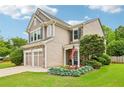 Beautiful two-story home with a stone and siding exterior, complemented by lush landscaping and an American flag at 5225 Stonehaven Vw, Cumming, GA 30040