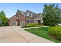 Spacious brick home featuring a three-car garage and meticulously maintained landscaping at 1393 Kings Park Nw Dr, Kennesaw, GA 30152
