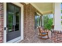 Inviting front porch with rocking chairs, brick accents, and a secure smart lock at 1393 Kings Park Nw Dr, Kennesaw, GA 30152