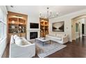 Spacious living room with hardwood floors, fireplace, built-in bookshelves and modern lighting at 1393 Kings Park Nw Dr, Kennesaw, GA 30152