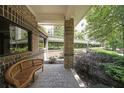 Covered patio area with bench seating, brick columns and lush landscaping with shade trees at 1800 Clairmont Lk # 213, Decatur, GA 30033
