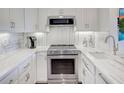 Galley kitchen equipped with stainless steel appliances, pristine white cabinets, and elegant marble countertops and backsplash at 300 Johnson Ferry Ne Rd # A706, Atlanta, GA 30328