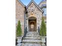 Stone steps lead to a wood front door framed by lush potted evergreens at 1031 Eulalia Ne Rd, Atlanta, GA 30319