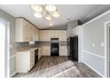 Well-lit kitchen with modern appliances, lots of cabinets, and hardwood floors and light gray walls at 2235 Azalea Dr, Loganville, GA 30052