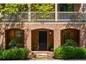 Close-up of the brick front entrance with an arched doorway, black door, and manicured landscaping at 970 N Ormewood Park Se Dr, Atlanta, GA 30316