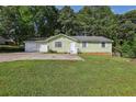 Charming single-story home with an attached two-car garage and a well-maintained front yard at 4954 Browns Mill Rd, Lithonia, GA 30038