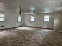 Spacious living room with neutral-toned carpet, multiple windows, and a vintage chandelier at 1142 Pluma Se Dr, Atlanta, GA 30316