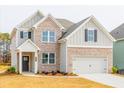Charming two-story home featuring a brick and gray facade, a two-car garage, and a well-manicured lawn at 1730 Fulmont Cir, Mableton, GA 30126