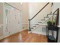 Bright foyer showcases hardwood floors, staircase with dark wood trim and white door, creating an elegant entry at 510 Morning Mist Ct, Alpharetta, GA 30022