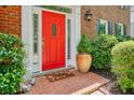 Inviting front entrance with a vibrant red door, brick walkway and lush greenery creates a warm welcome at 510 Morning Mist Ct, Alpharetta, GA 30022