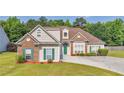 Charming two-story home with a well-manicured lawn, attached garage, green door and lush landscaping at 127 Autumn Run Pl, Villa Rica, GA 30180
