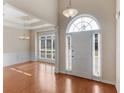 Bright foyer boasts gleaming hardwood floors, a tray ceiling, elegant lighting, and arched entryways at 127 Autumn Run Pl, Villa Rica, GA 30180