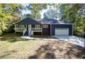 Charming home with blue siding, white trim, a cozy front porch, and a one car garage at 1342 Carter Rd, Decatur, GA 30030