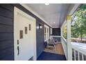 Inviting front porch with rocking chairs, wood flooring, and a stylishly painted front door at 1342 Carter Rd, Decatur, GA 30030