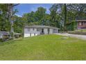 A well-kept single-story home with a lush front yard and a beautiful, dark shingled roof at 2636 Flagstone Se Dr, Atlanta, GA 30316