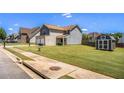 Two-story house boasts a spacious yard with a storage shed, great curb appeal, and sidewalk at 1932 Sawgrass Dr, Hampton, GA 30228