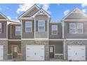 Modern townhomes feature a mix of gray siding, brick, and contrasting trim details at 227 Ivey Ter, Temple, GA 30179