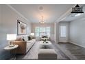 Bright living room featuring neutral paint, carpet and vinyl flooring, and natural light from a large window at 2557 Woodford Ln, Buford, GA 30519